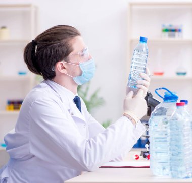 Laboratuvarda deney yapan genç erkek kimyager.