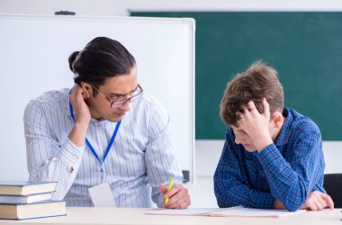 Sınıftaki genç erkek öğretmen ve çocuk.