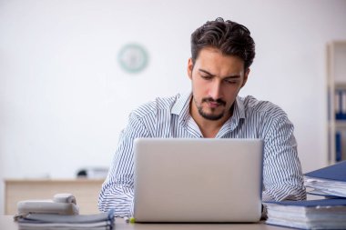 Genç işadamı ve ofiste çok fazla iş var.