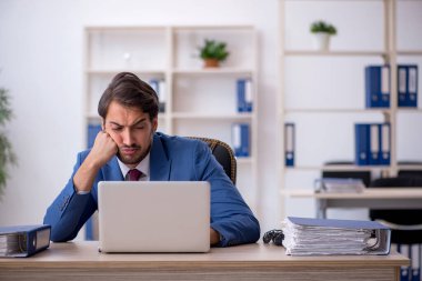 Genç işadamı ve ofiste çok fazla iş var.