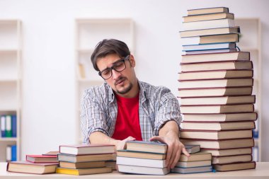 Genç bir öğrenci ve sınıfta çok fazla kitap var.