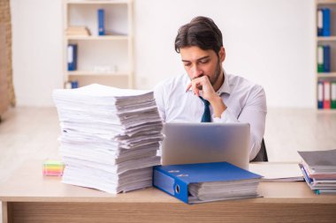 Genç erkek çalışan işyerinde aşırı çalışmaktan memnun değil.