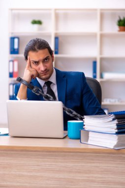 Zincirlenmiş çalışan, Ofis 'te aşırı çalışmaktan memnun değil.