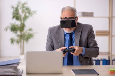 Eski işadamı ofiste sanal bardakların keyfini çıkarıyor.