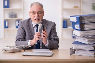 Ofisteki aşırı işten memnun olmayan eski bir işadamı.