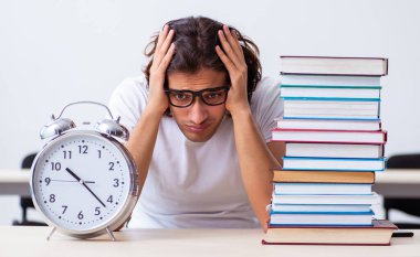 Sınıfta oturan genç erkek öğrenci.