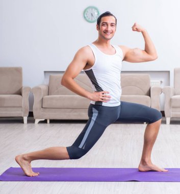 Genç adam evde antrenman ve egzersiz yapıyor.