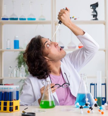 Laboratuvarda çalışan komik erkek kimyager.