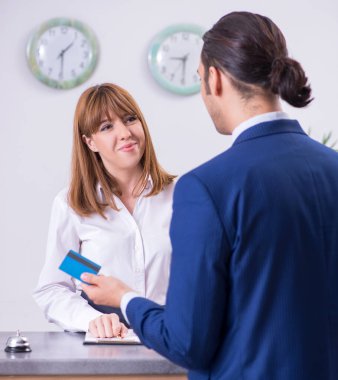 Otel resepsiyonundaki genç işadamı.