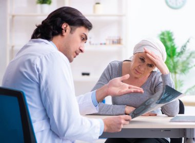 Genç erkek doktor ve kadın onkoloji hastası.