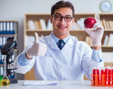 Bilim adamı organik meyve ve sebzeler üzerinde çalışıyor.