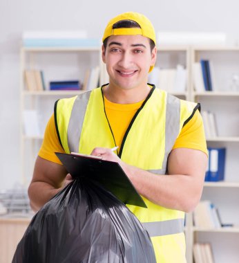 Ofisi temizleyen ve çöp torbası tutan adam.