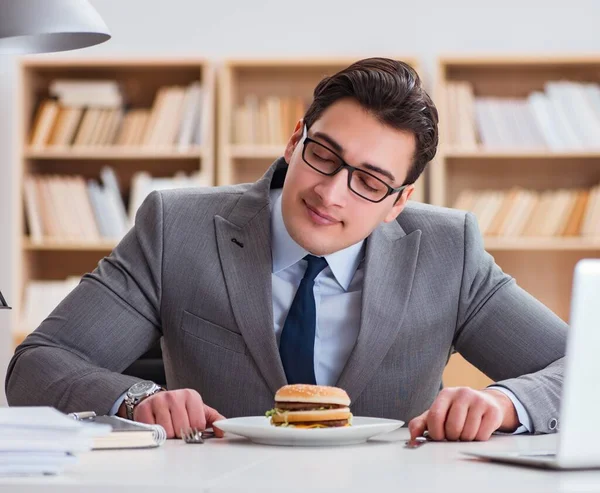 空腹の面白いビジネスマンがジャンクフードのサンドイッチを食べて — ストック写真