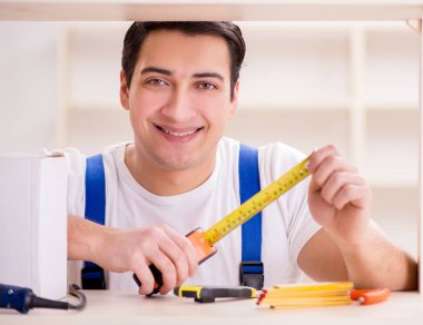 Çalışan adam kitaplığı tamir ediyor.