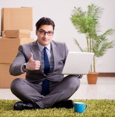 Ofisteki halının üzerinde oturan işadamı.