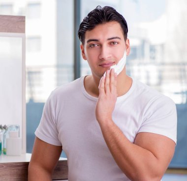 Genç yakışıklı adam sabahları tıraş oluyor.