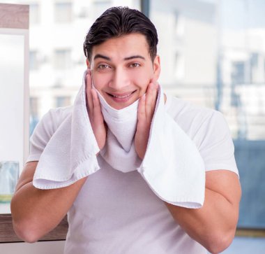 Yüz kremi süren genç yakışıklı adam.