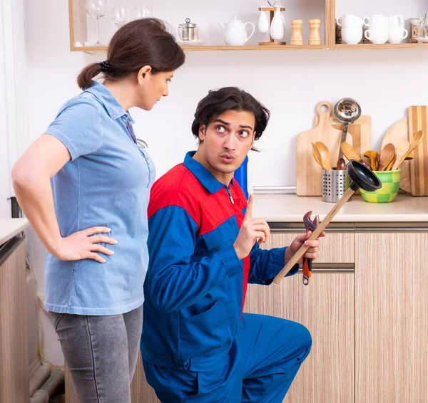 stock image The young male repairman repairing tap