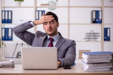 Genç işadamı işyerinde oturuyor.