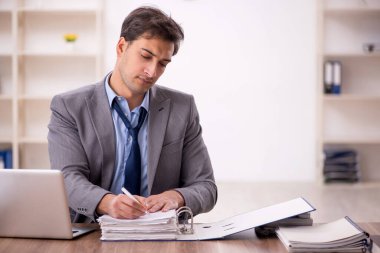 Genç işadamı işyerinde oturuyor.