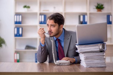 Genç işadamı işyerinde oturuyor.