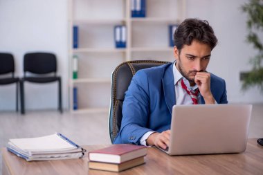 Genç işadamı ve işyerinde çok fazla iş var.