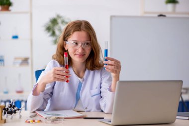 Laboratuvarda çalışan genç bir kimyager kız.