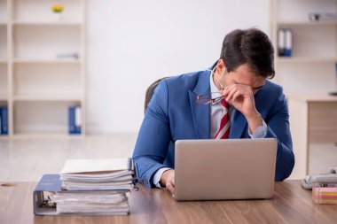 Genç işadamı işyerinde oturuyor.