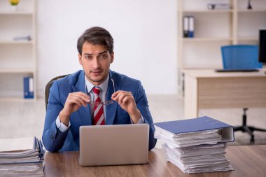 Genç işadamı işyerinde oturuyor.