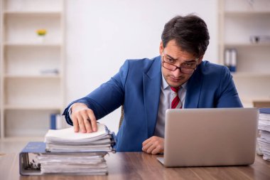 Genç işadamı işyerinde oturuyor.