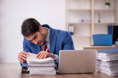 Genç işadamı işyerinde oturuyor.