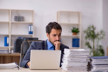 Genç işadamı ve ofiste çok fazla iş var.