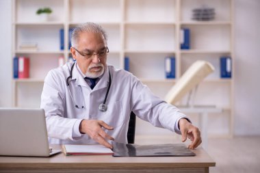 Hastanede çalışan yaşlı bir radyoloji uzmanı.