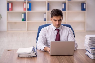 Genç işadamı ve ofiste çok fazla iş var.