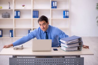 Genç işadamı ve işyerinde çok fazla iş var.