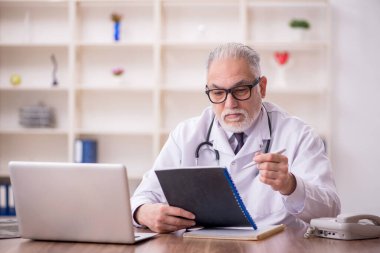 Hastanede çalışan yaşlı erkek doktor.