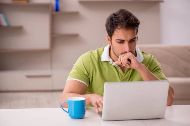 Genç erkek serbest çalışan salgın sırasında evden çalışıyor.