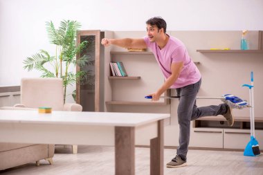 Genç müteahhit evi temizliyor.