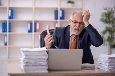 Ofisteki aşırı işten memnun olmayan eski bir işadamı.