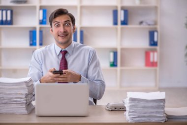 Genç işadamı ve ofiste çok fazla iş var.