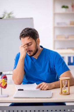 Zaman yönetimi konseptinde genç doktor kardiyolog