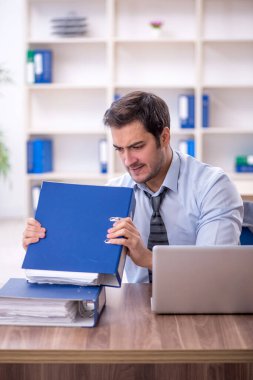 Ofisteki aşırı işten memnun olmayan genç bir çalışan.