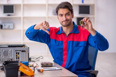 Atölyede bilgisayar tamir eden genç bir tamirci.