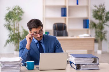 Genç işadamı ve işyerinde çok fazla iş var.