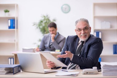 İki erkek çalışan işyerinde çalışıyor.