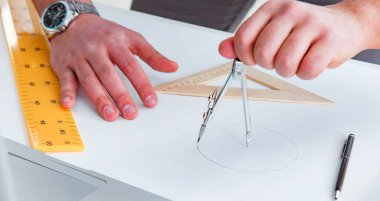 Erkek mühendis çizimler ve planlar üzerinde çalışıyor.