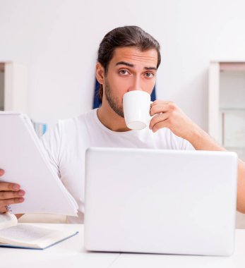 Genç erkek öğrenci evde sınavlara hazırlanıyor.