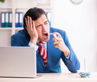 Ofiste acı çeken genç bir erkek işçi.