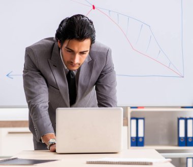 Genç yakışıklı iş adamı beyaz tahtanın önünde.