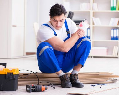 Zemin kaplamalarında çalışan genç işçi.